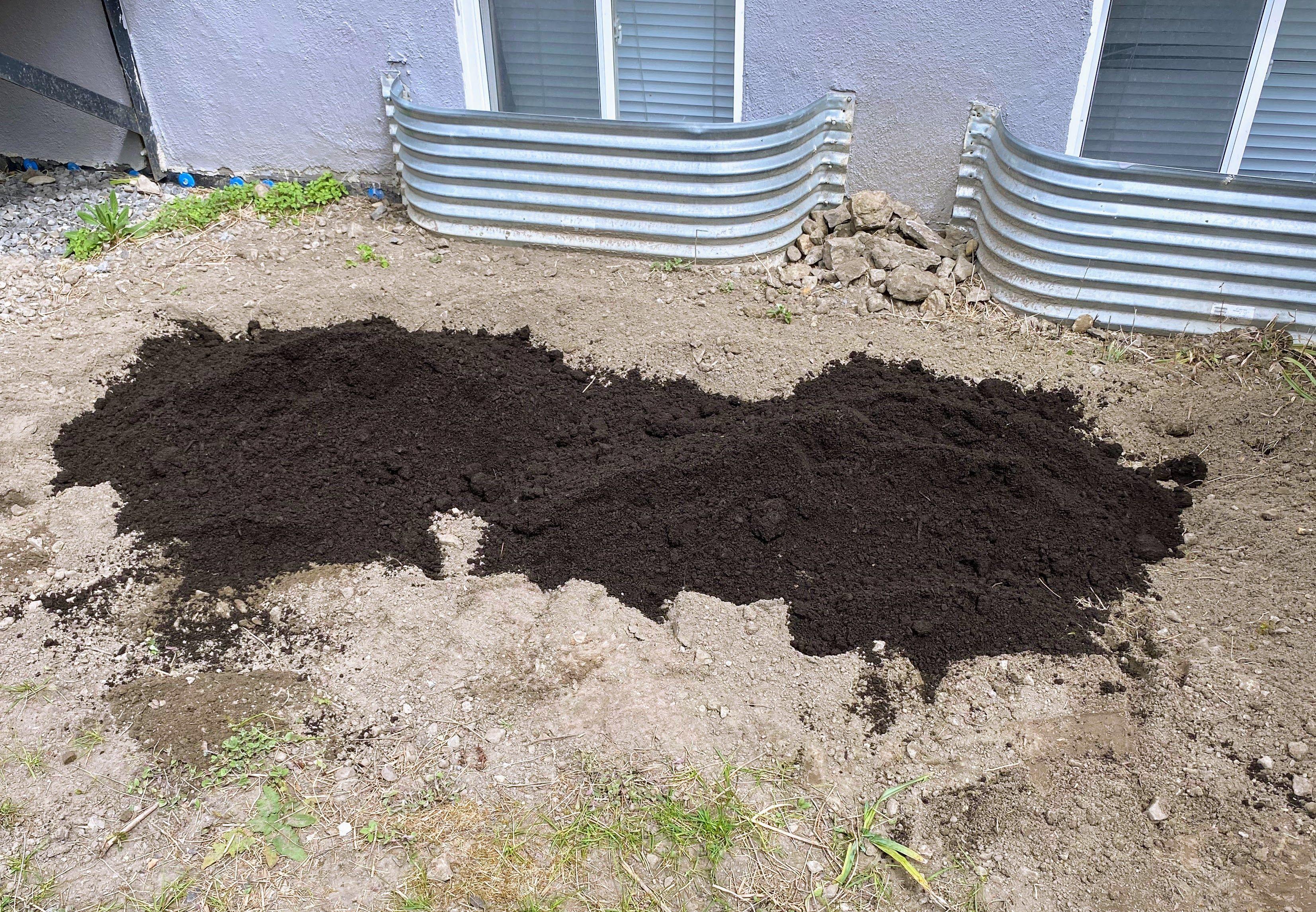Fresh soil meeting a perfectly prepped bed—rototilled, cleared of rocks, and ready for levelling and planting.