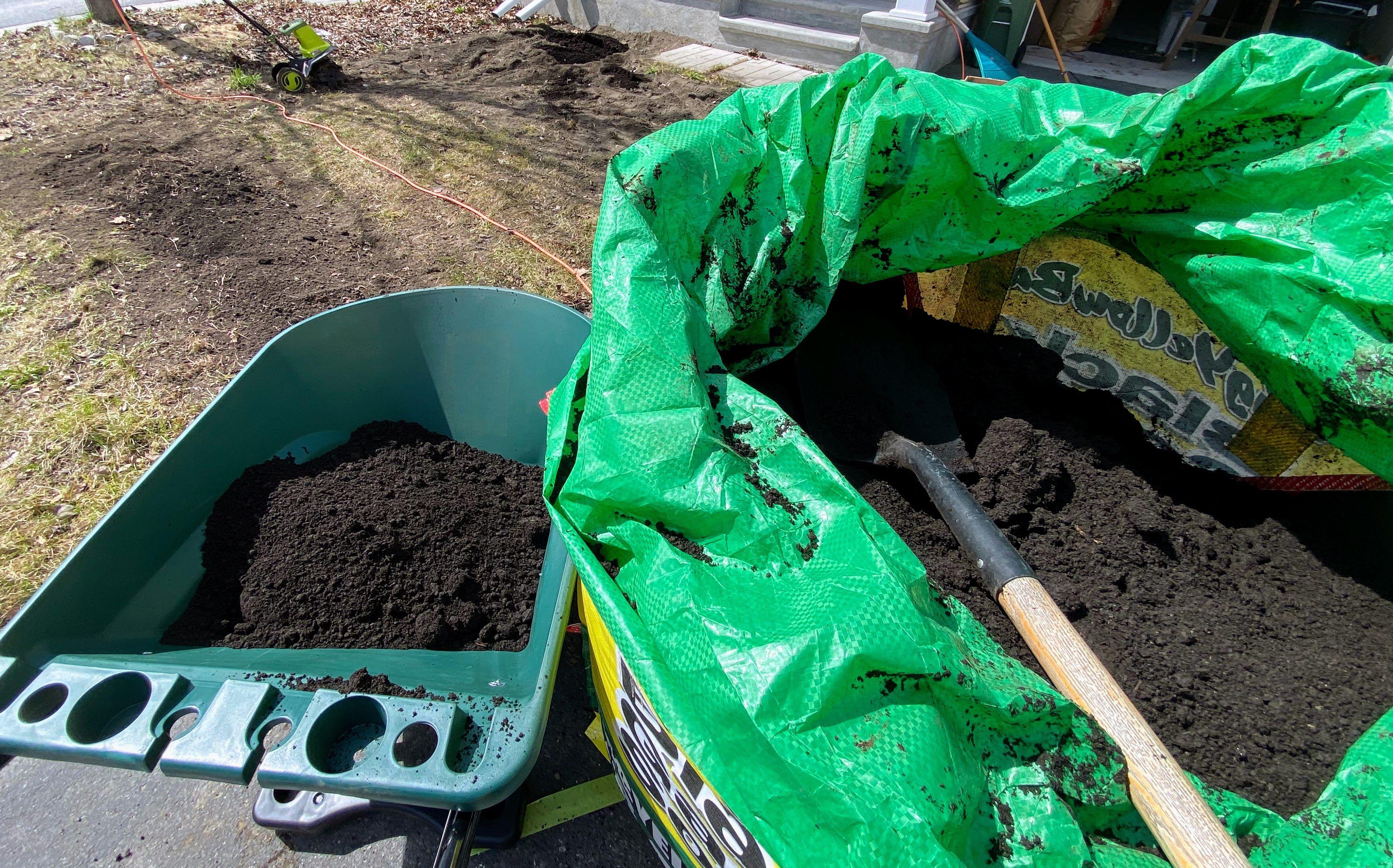 A wheelbarrow is being loaded with soil from a soil in a bag delivery service in Kanata.